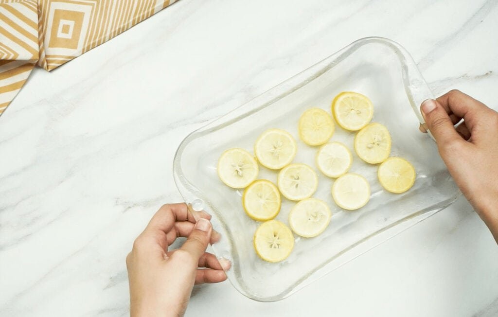 A woman holding a plastic tray of lemon slices