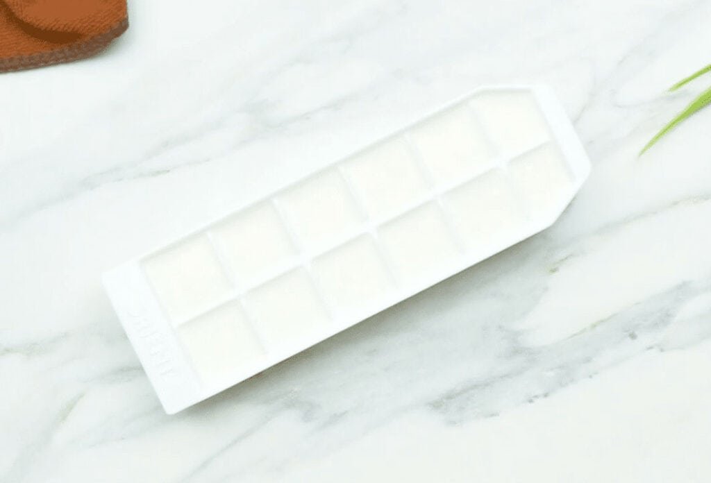 An ice cube tray filled with almond milk